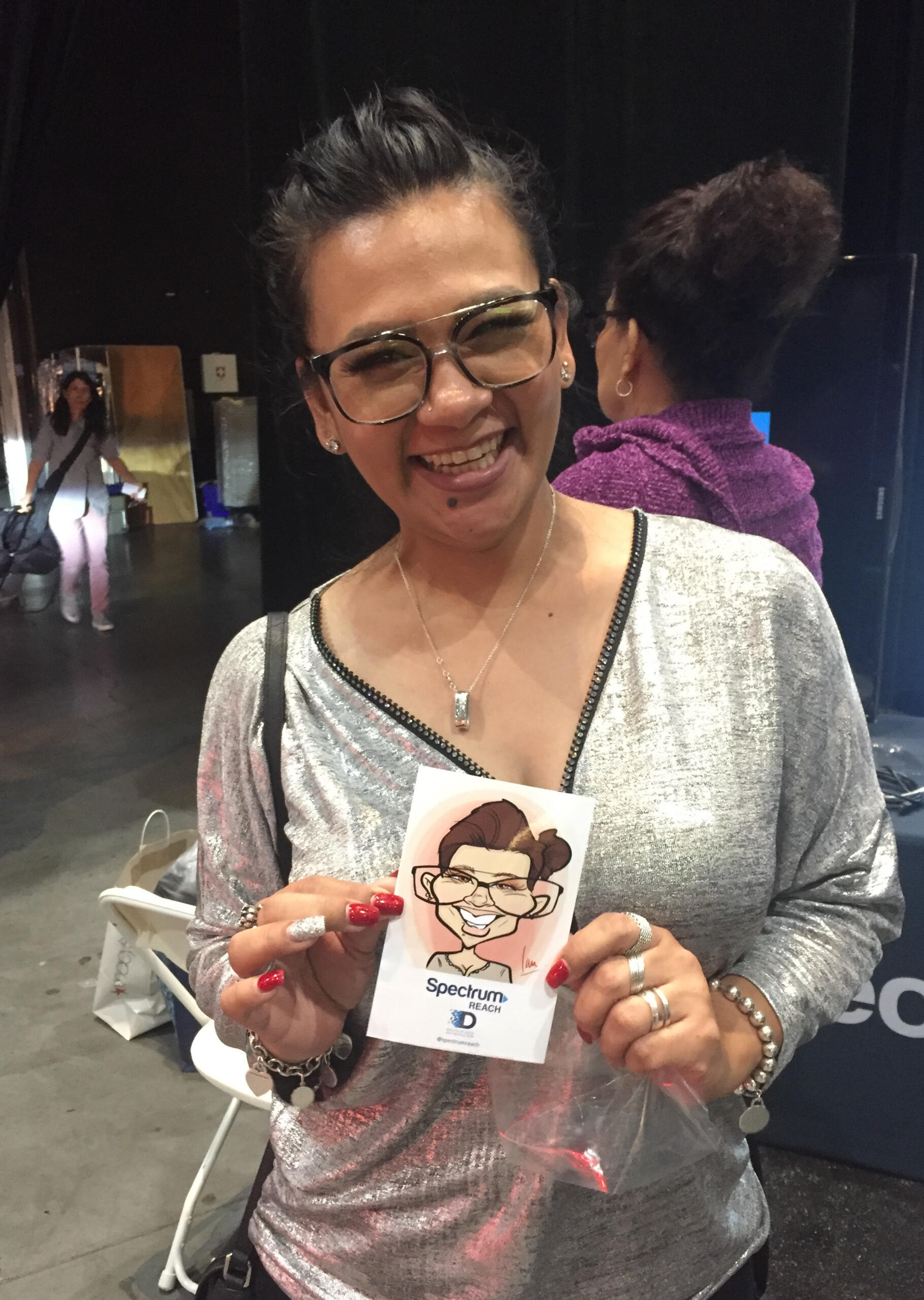 A happy convention guest showing her printed caricature art.